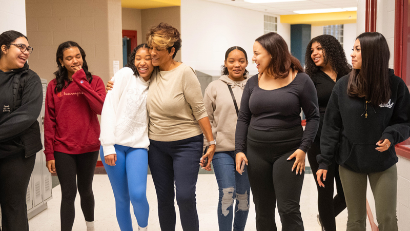 A group of women walking in a hallway.