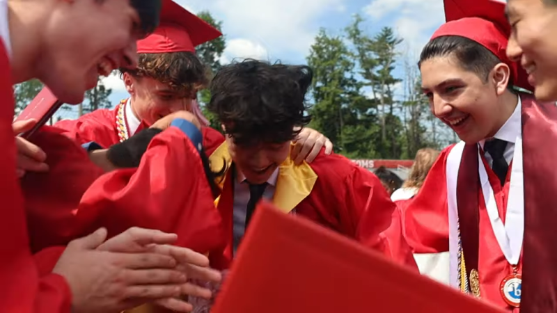 Graduates in regalia celebrate. 