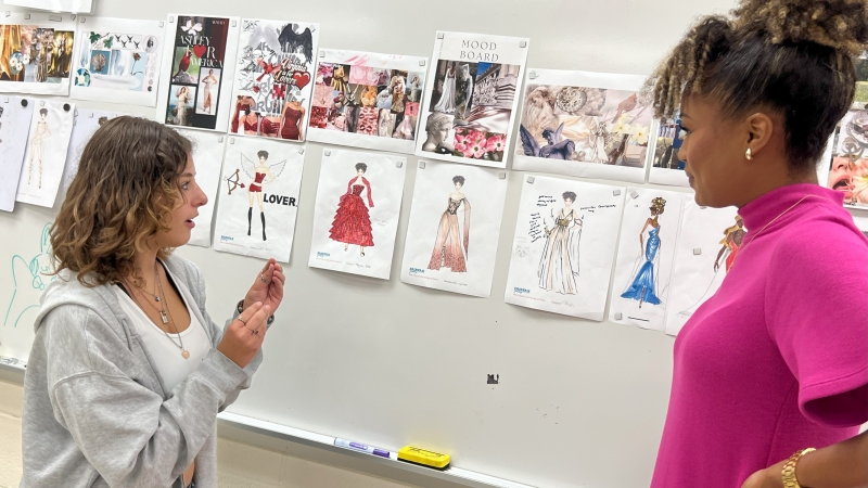 Student presents design sketch to Miss Virginia USA