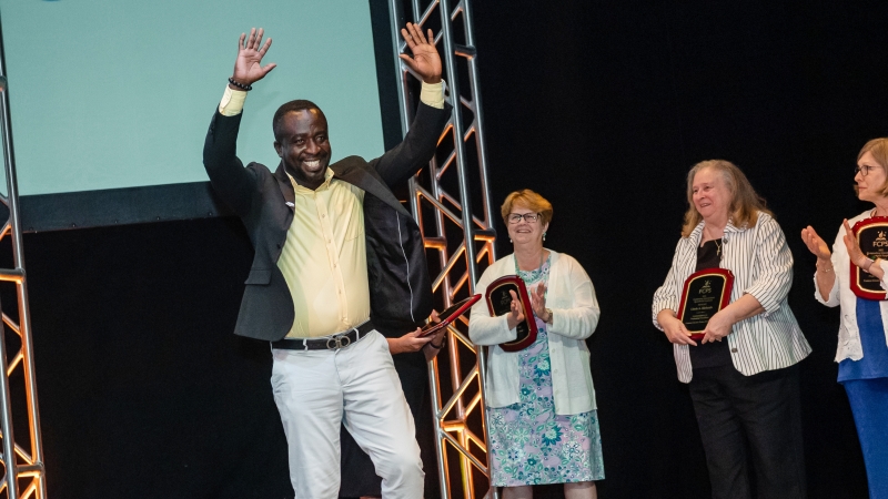 Award winner raising his hands at FCPS Honors 2022. 