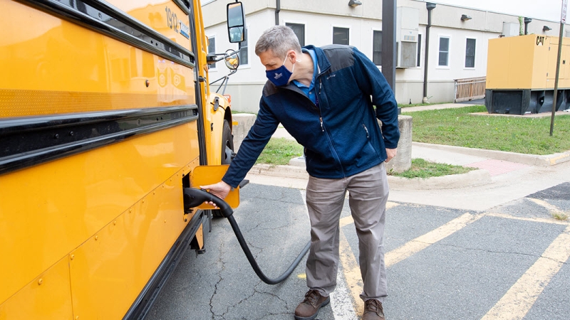 School Bus Driver Charging an Electric Bus