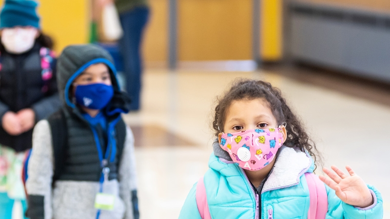 Photo of students in coats and masks. 