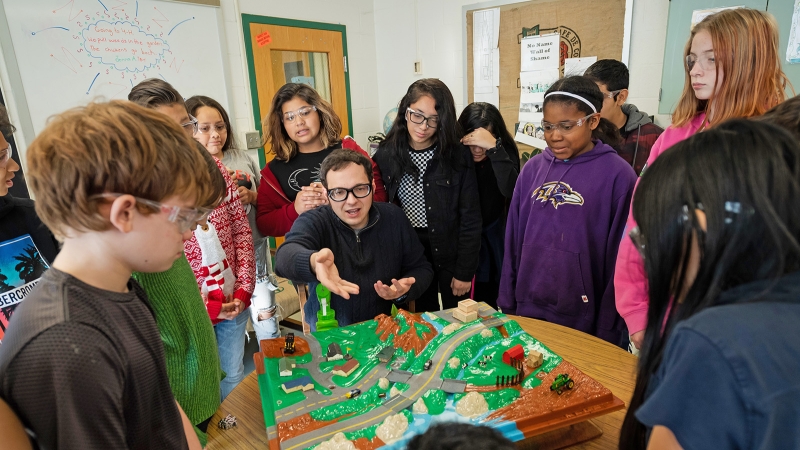 teacher explaining town model to students