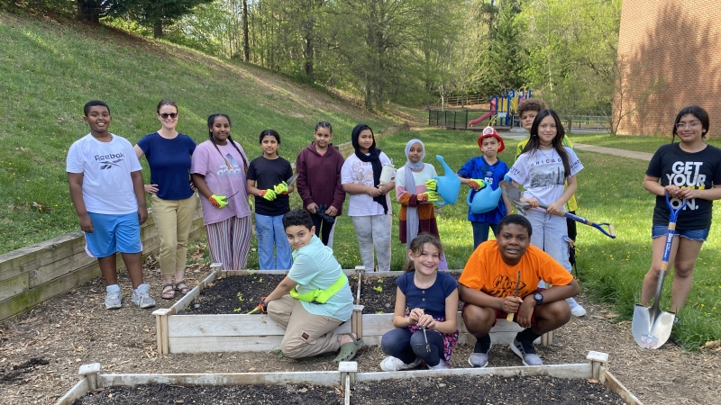 students gathered around raised garden beds