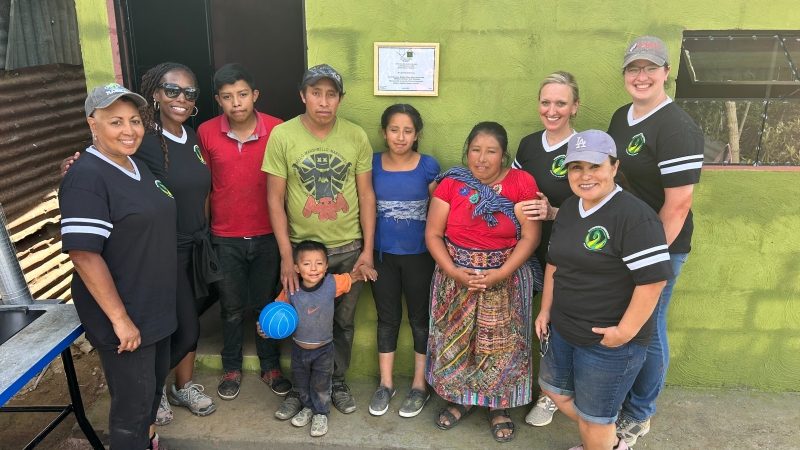 A group of Dogwood Elementary School teachers and administrators stand in front of a home they built for a family in Guatemala.