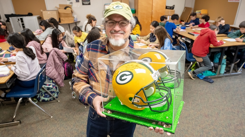 Twenty-year FCPS math teacher Paul Malc shows off his Green Bay Packers autographed helmet.