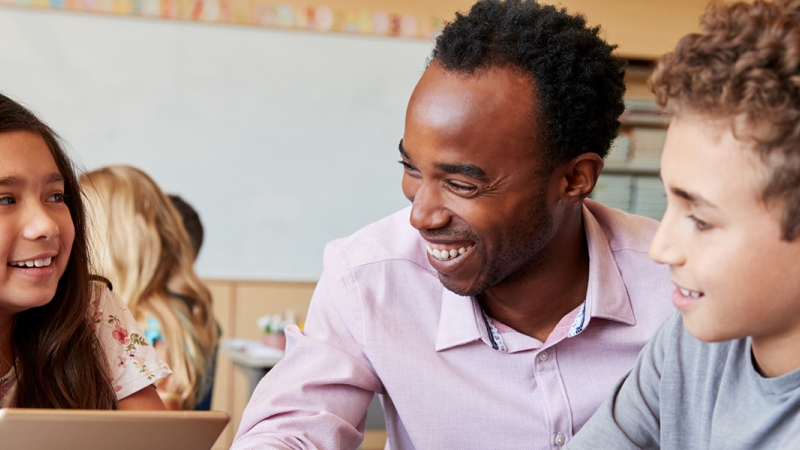 teacher smiling with two students