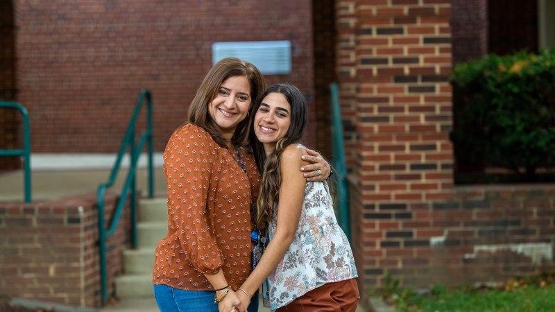 Laurel Ridge Elementary teacher Lesliean Luna, recruited from Puerto Rico, and her daughter, Bailey's Upper Elementary teacher Gabriela Muriente, embrace in a school hallway.