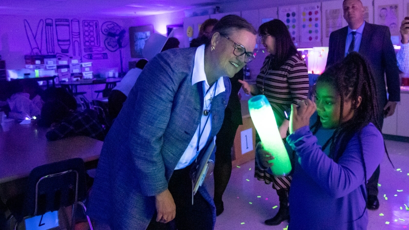 Dr. Reid with student in black light experiment