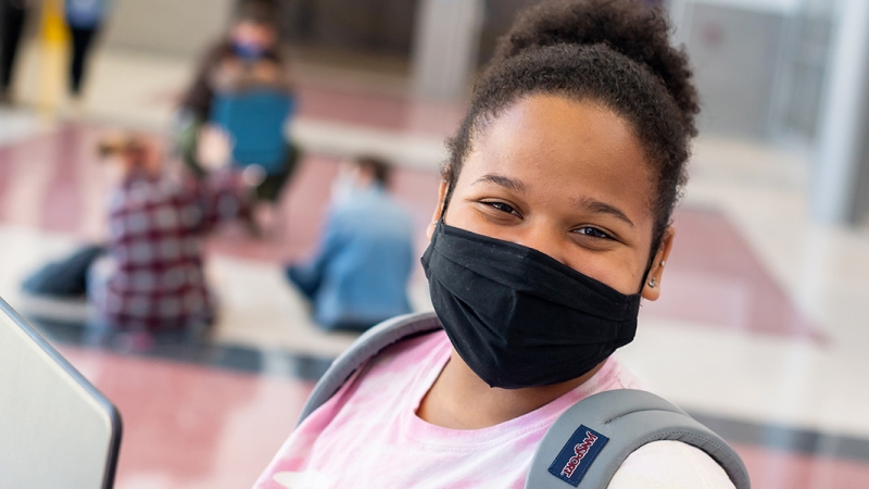 girl in mask with laptop