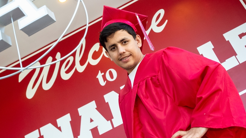 Annandale High School senior Samiullah Luddin tries on his cap and gown as he prepares to graduate.