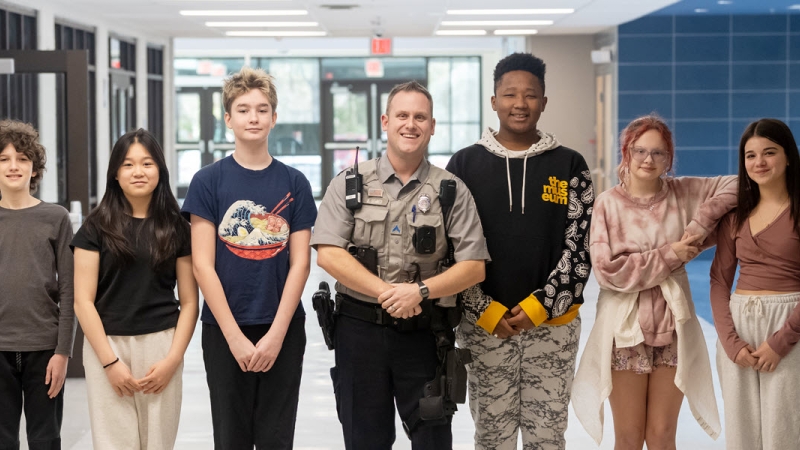 School Resource Officer with students in hallway