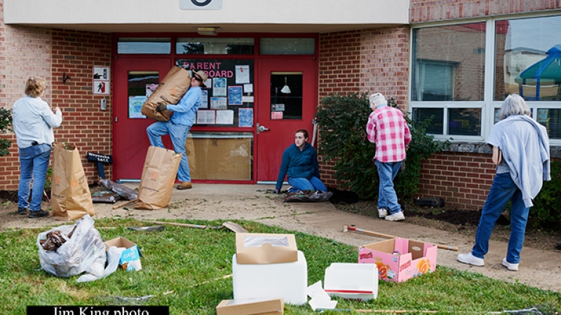 volunteers working on landscaping outside a school