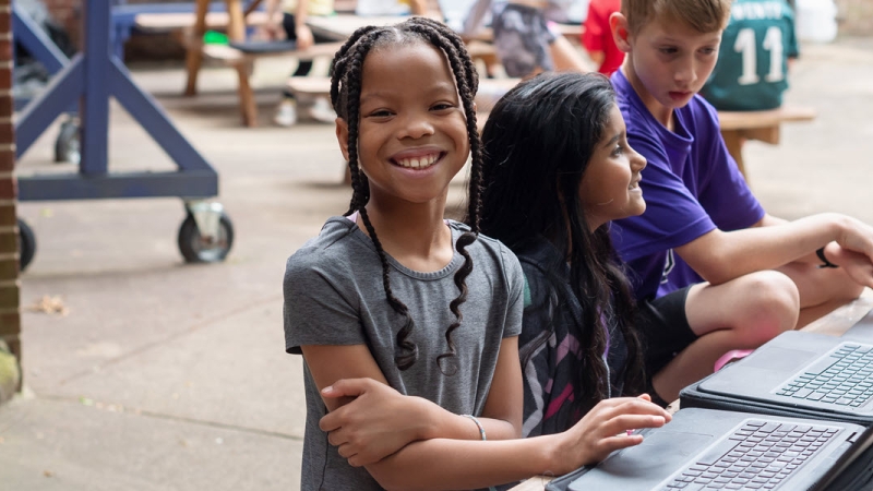 students with laptops outside