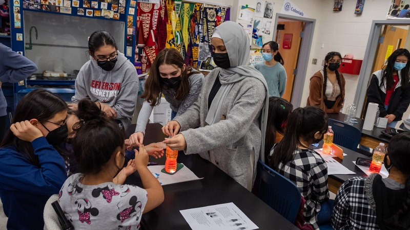 Students at Thomas Jefferson High School for Science and Technology lead fifth-grade girls from nearby Weyanoke Elementary in the chemical process required to create lava lamps in empty water bottles.