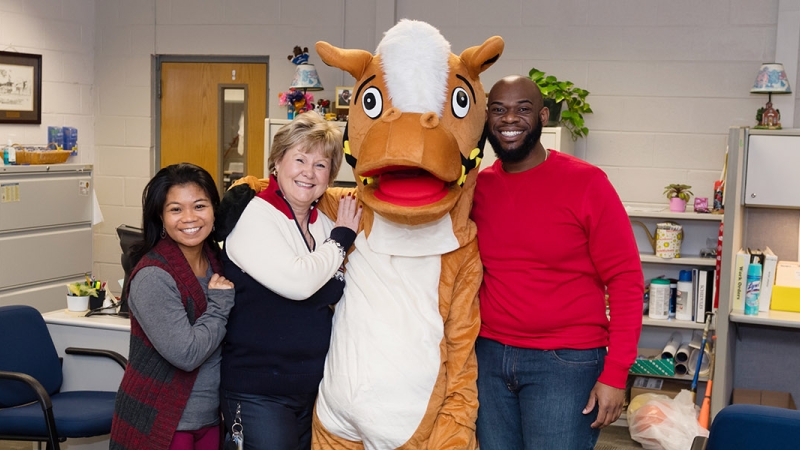 a photo of staff members with a mascot