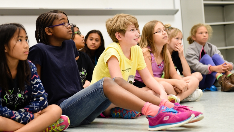 Photo of students sitting on the floor