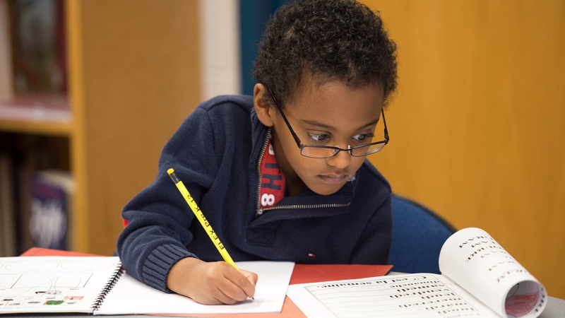 Photo of a male student reading and writing