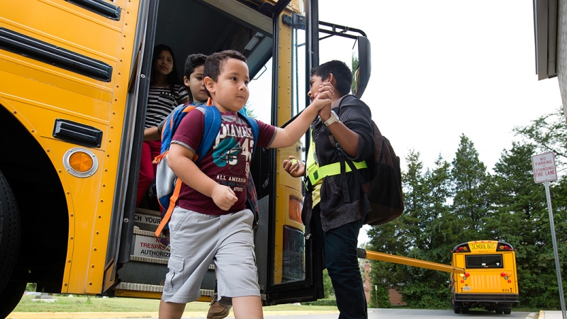 a photo of a young student getting off the bus.