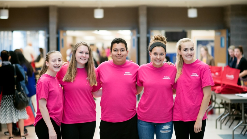Five students wearing pink shirts