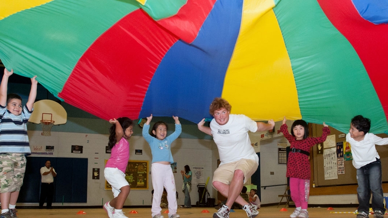 Students with a parachute in physical education class
