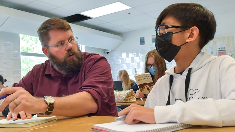 high school teacher helping a student