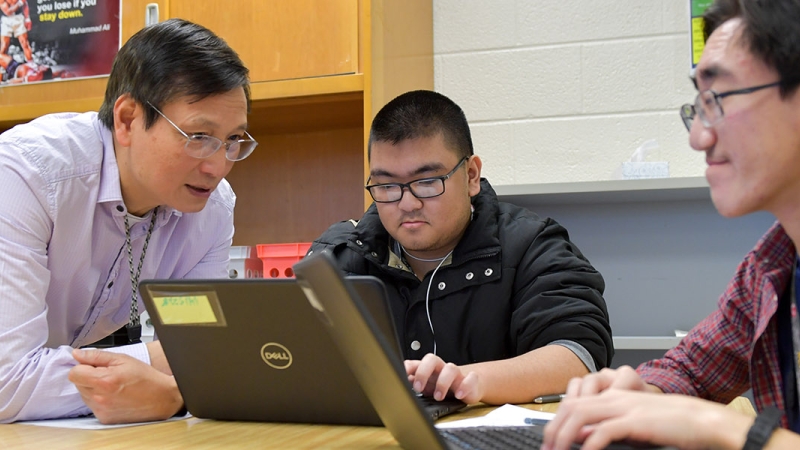 a high school teacher helping students