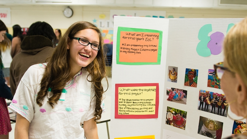 student with project presenting to teacher