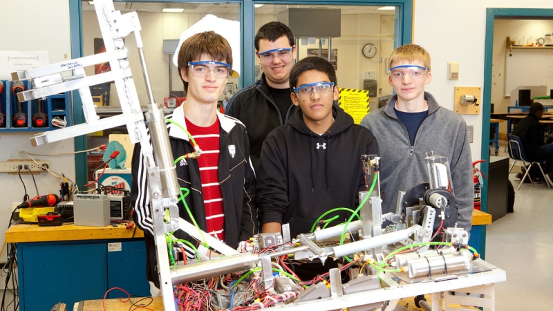 four male students standing behind a tech ed project