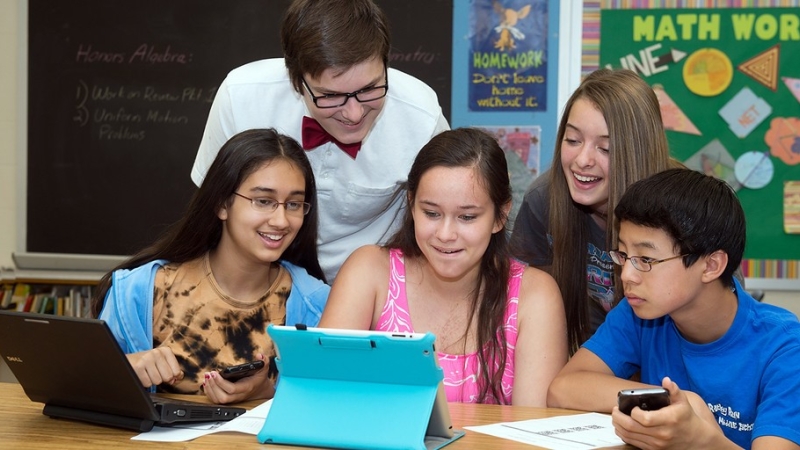 photo of a group of students collaborating around a device
