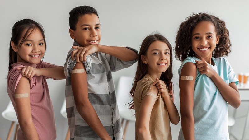 Elementary age students with bandages on their arms. 