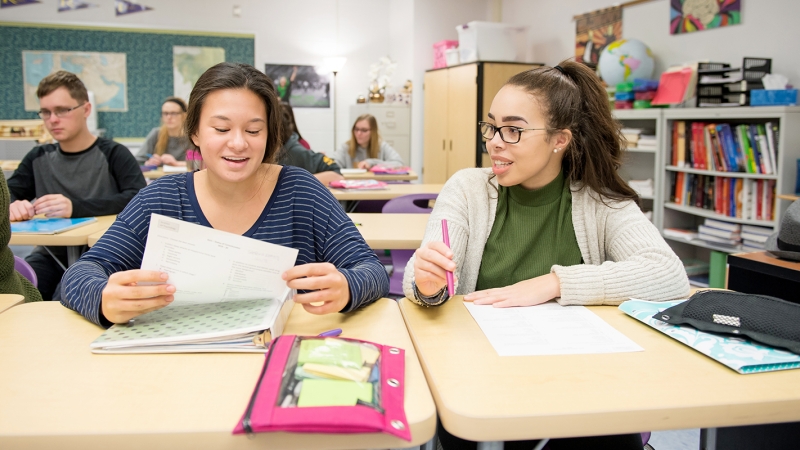 Photo of two students sitting at their desks
