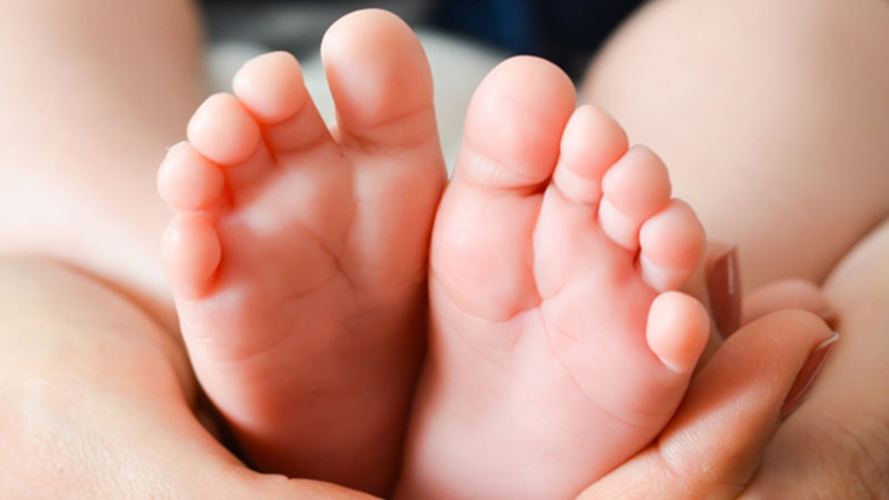 mother holding young baby's feet