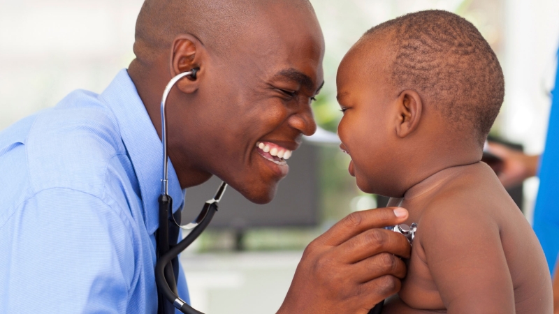 doctor with a stethoscope to baby's chest