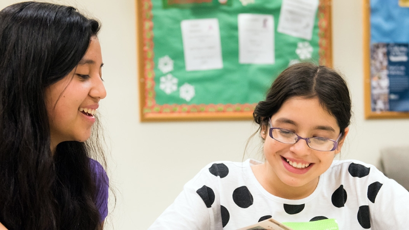 a photo of a teacher and a student reading