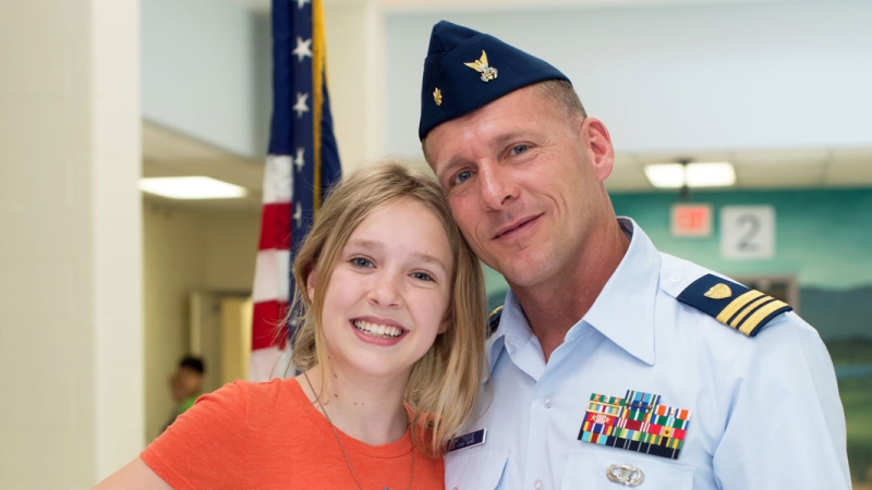 Photo of a father wearing a military uniform with his daughter