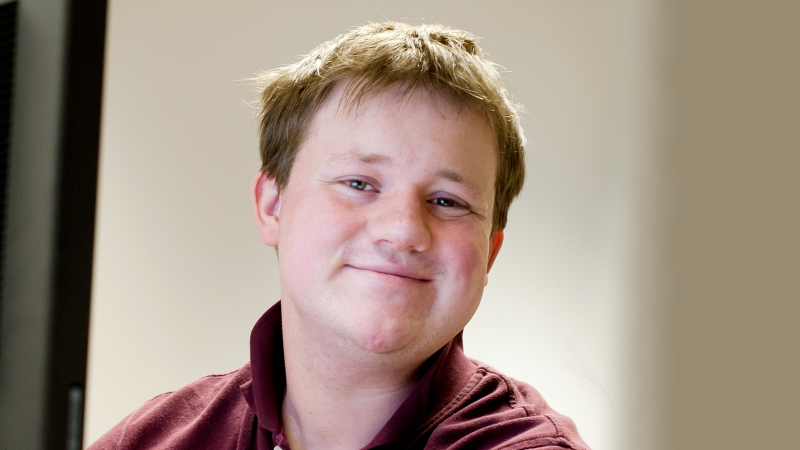 male student sitting at a computer