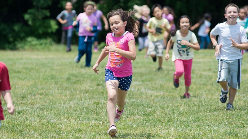 Photo of children running on grass