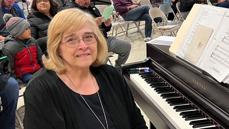 Woman sitting at a piano.