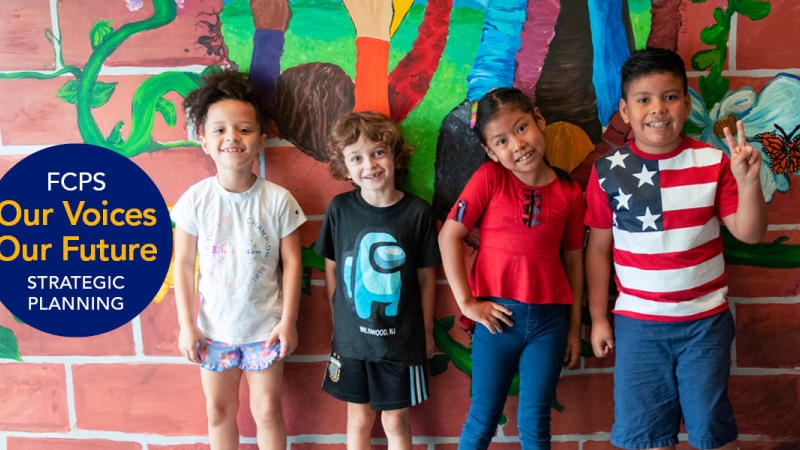 four elementary school students in front of mural 