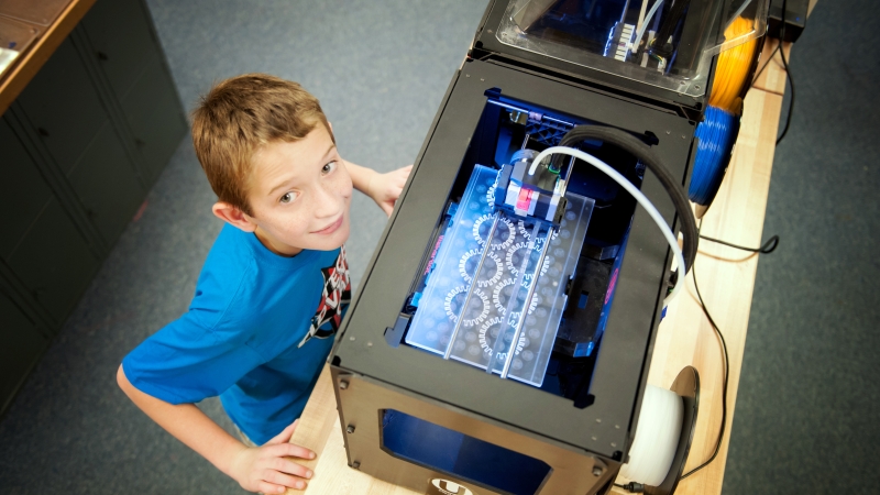 student at the tech adventure summer camp working on a 3D printer