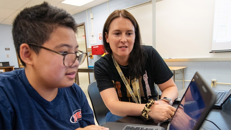 student and adult using a computer