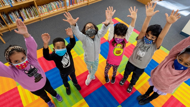 several children with arms in the air