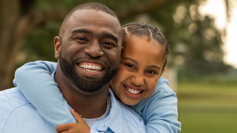 father and daughter with trees in the background