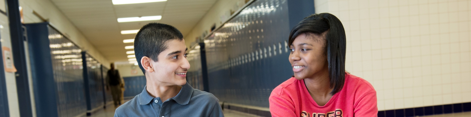 students on computers in a school hallway