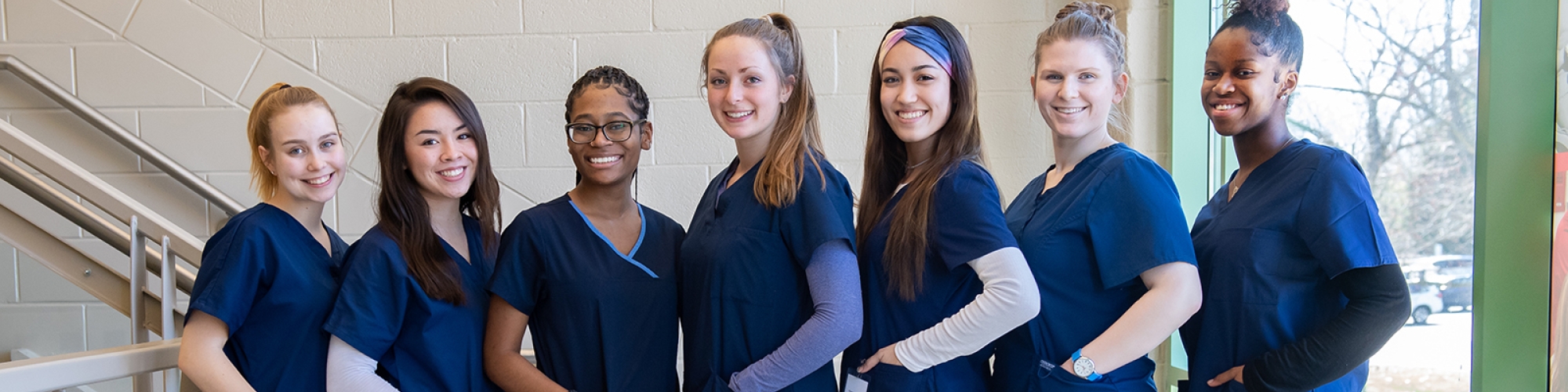 seven female medical students standing in a line