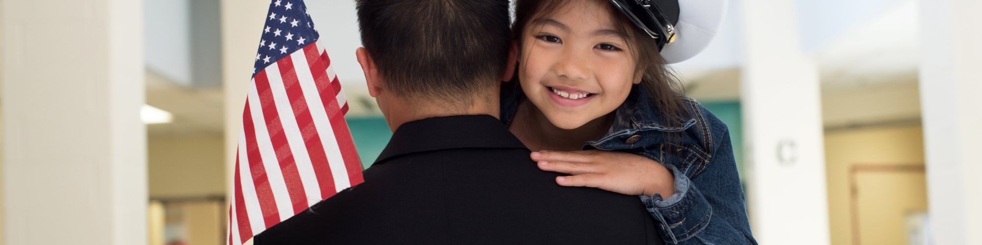 Child being carried by dad, member of the U.S. military.