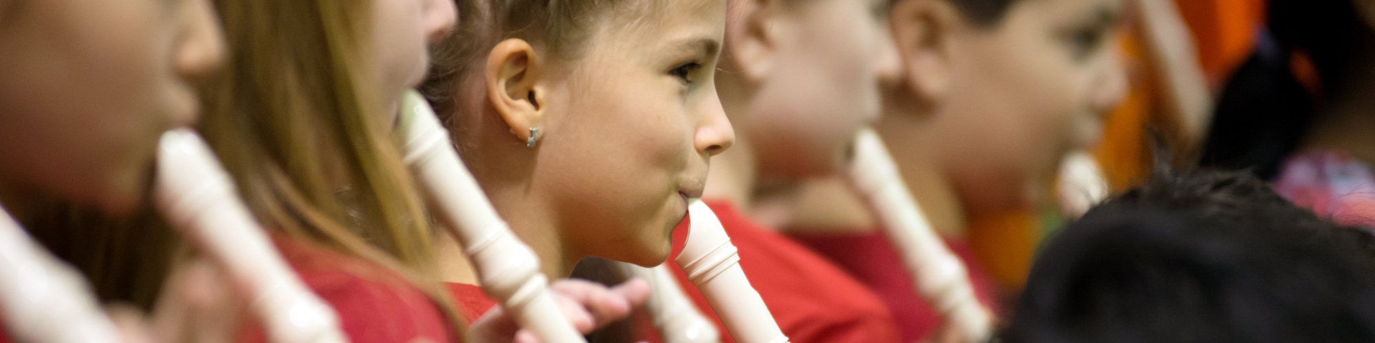 Elementary school students playing recorders.