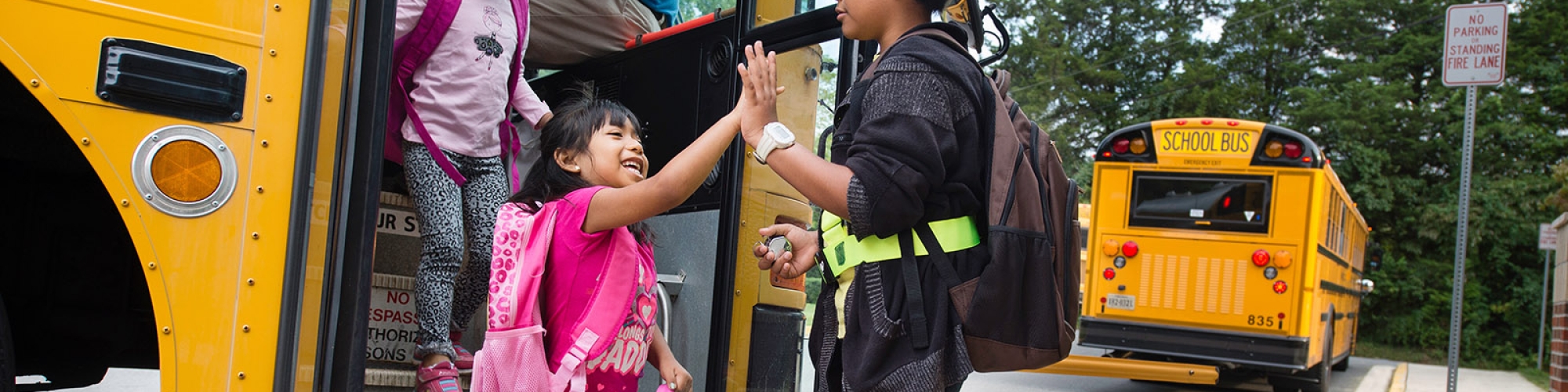 Safety patrol helping student off of bus