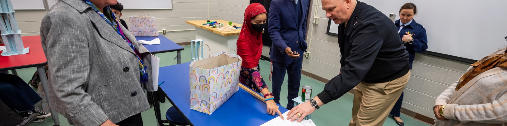 A student shows off his paper tower project. 